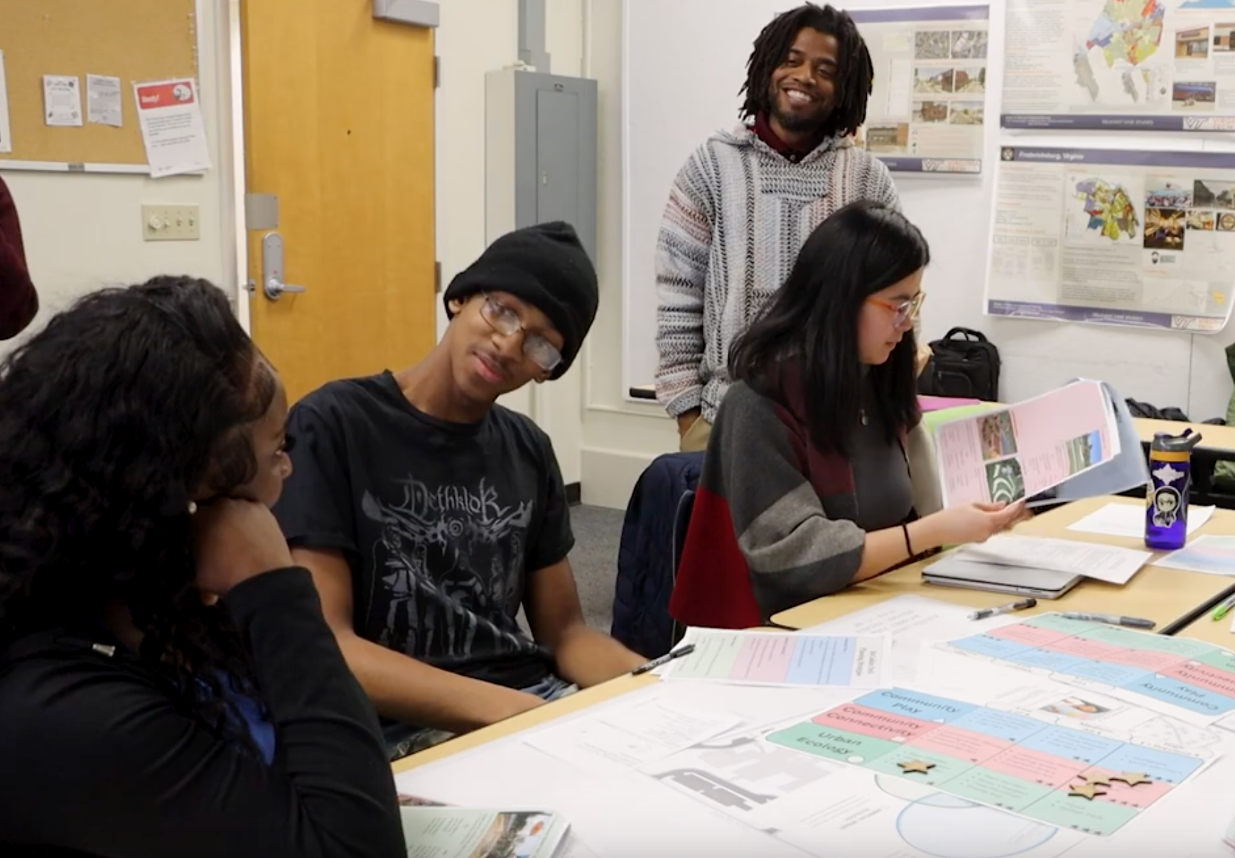 Students around a table with papers and star shaped markers on it
